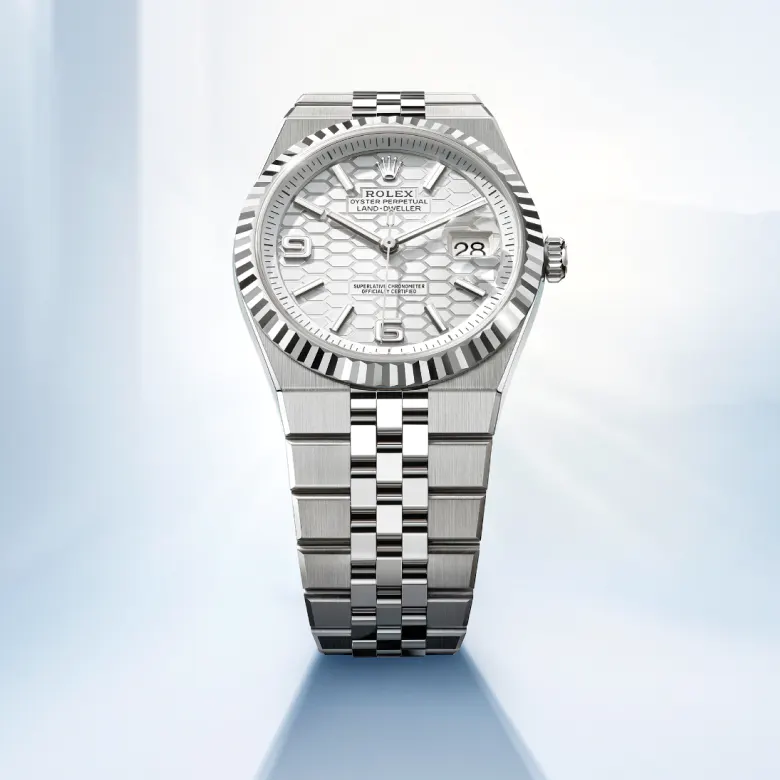 rolex Land-Dweller    - Questo quadrante è impreziosito dal motivo a nido d’ape con finitura satinata. Per realizzarlo, il Marchio ha fatto ricorso sia alle tecniche tradizionali, sia ai procedimenti di alta tecnologia, tutti perfettamente dominati in‑house. Il taglio degli alveoli e l’esecuzione delle striature all’interno delle scanalature che li separano richiedono l’intervento del laser a femtosecondi. Il quadrante dispone della visualizzazione Chromalight, con numeri aperti e indici luminescenti che gli conferiscono una leggibilità ottimale in ogni circostanza. Le lancette, anch’esse luminescenti, sono state appositamente disegnate per questo modello.